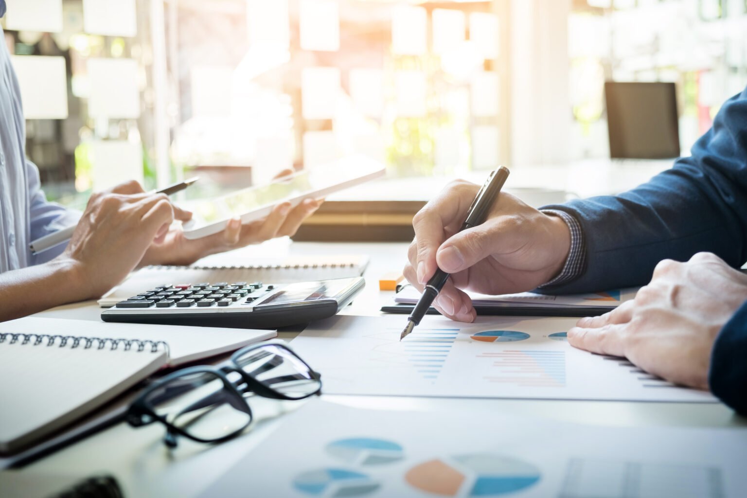 Bookkeeper reviewing financial documents and reconciling accounts at a desk